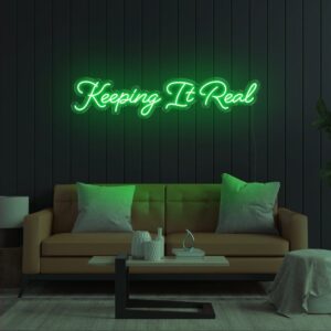 A glowing neon sign with the phrase 'Keeping It Real' in vibrant colors, evoking honesty and integrity.