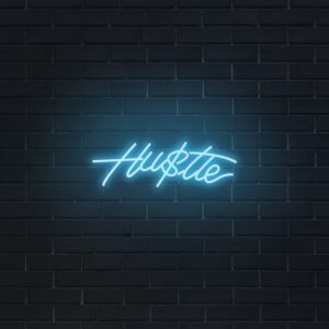 A glowing neon sign with the word 'Hustle' in vibrant colors, evoking determination and drive.