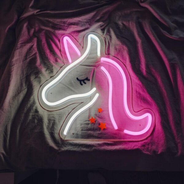 A glowing neon sign depicting the silhouette of a unicorn in vibrant colors, evoking whimsy and magic.