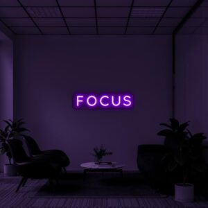 A glowing neon sign with the word 'FOCUS' in vibrant colors, evoking determination and motivation.