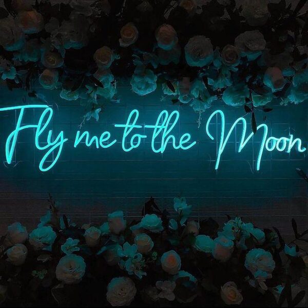 A glowing neon sign with the phrase 'Fly Me to the Moon' in vibrant colors, evoking dreams of exploration and adventure.