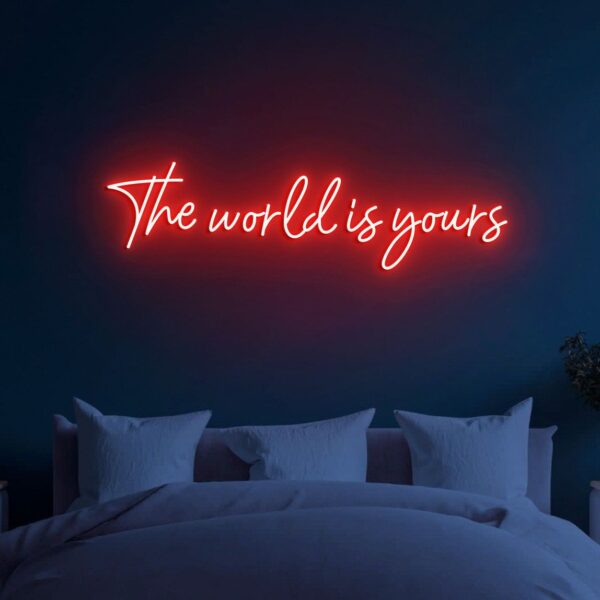 A glowing neon sign with the phrase 'The World is Yours' in vibrant colors, evoking ambition and possibility.