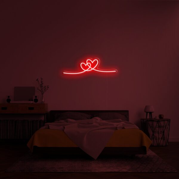 A glowing neon sign depicting an array of hearts in vibrant colors, symbolizing love and affection.