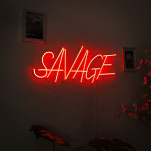 A glowing neon sign with the word 'Savage' in vibrant colors, evoking confidence and strength.