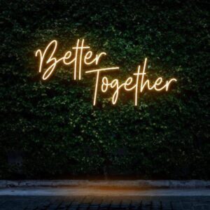 A glowing neon sign with the phrase 'Better Together' in vibrant colors, evoking unity and companionship.