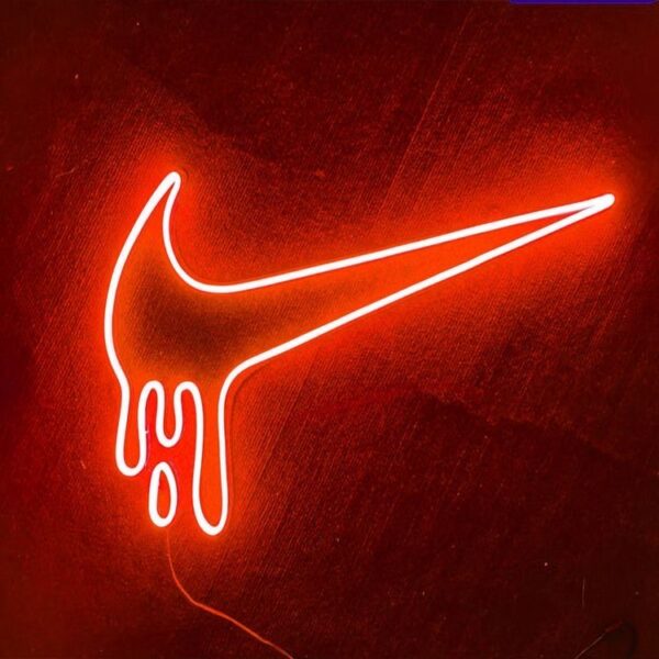 Neon sign featuring the Nike swoosh logo in bright white, glowing against a dark background.