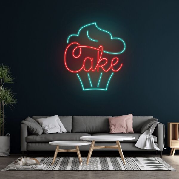 Colorful neon sign featuring a pink and blue cupcake with a cherry on top, glowing brightly against a dark background.