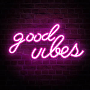 Neon sign displaying the words 'Good Vibes' in bright, fluorescent colors against a dark background, creating a warm and inviting glow in the room.